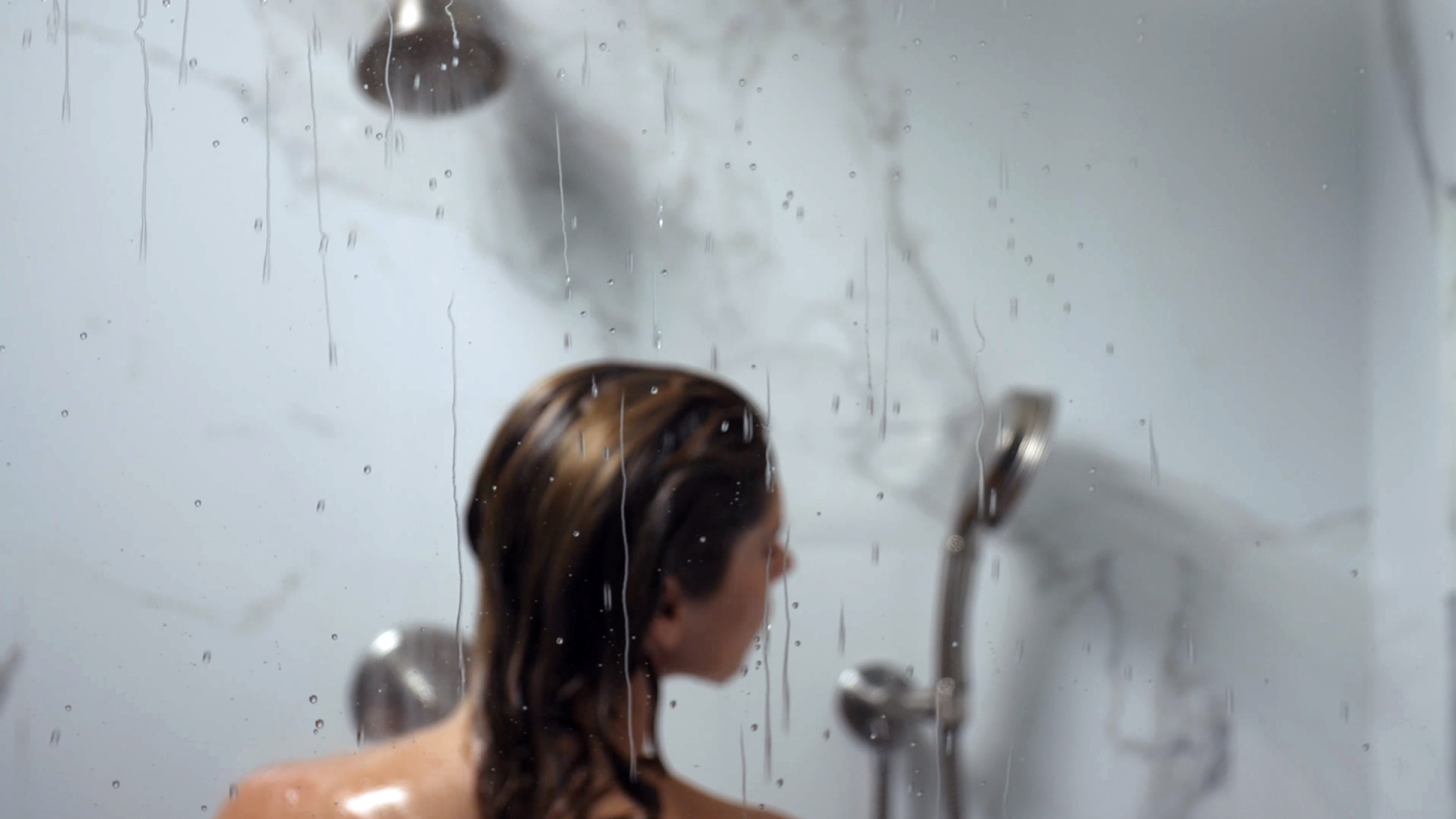 Water Beads on Shower Glass with Woman in Background
